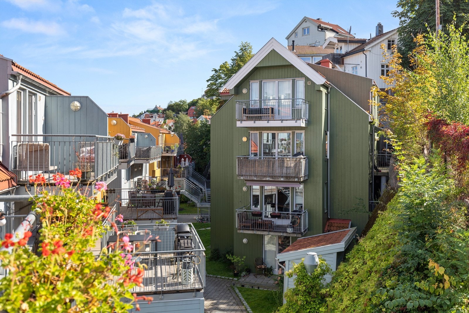 Borettslaget består av fargerike trehus som omkranser et barnevennlig tun på baksiden. (bilde fra sommer) Galleribilde