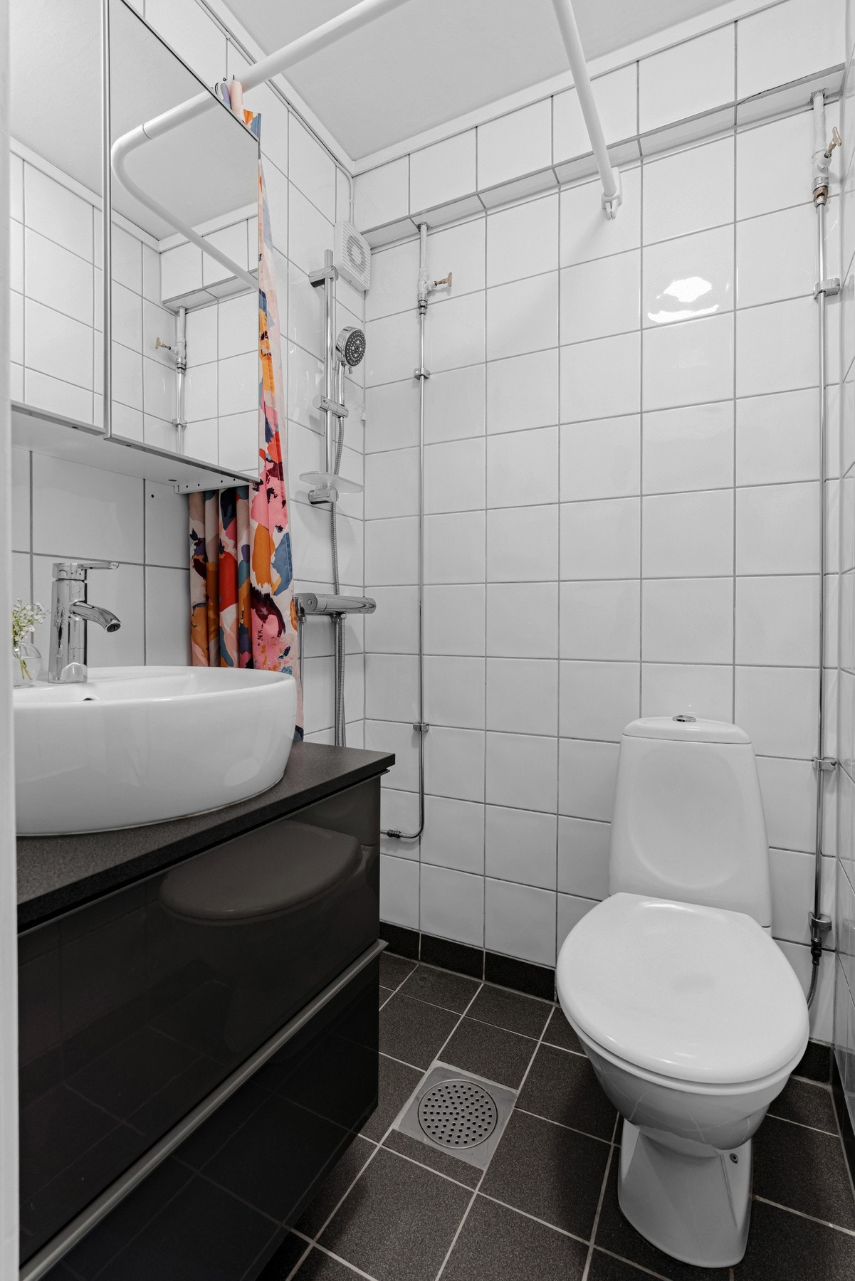 Selvom badet er lite er plassen godt utnyttet. Det er helfliset, har varmekabler og er tidløst innredet. Galleribilde
