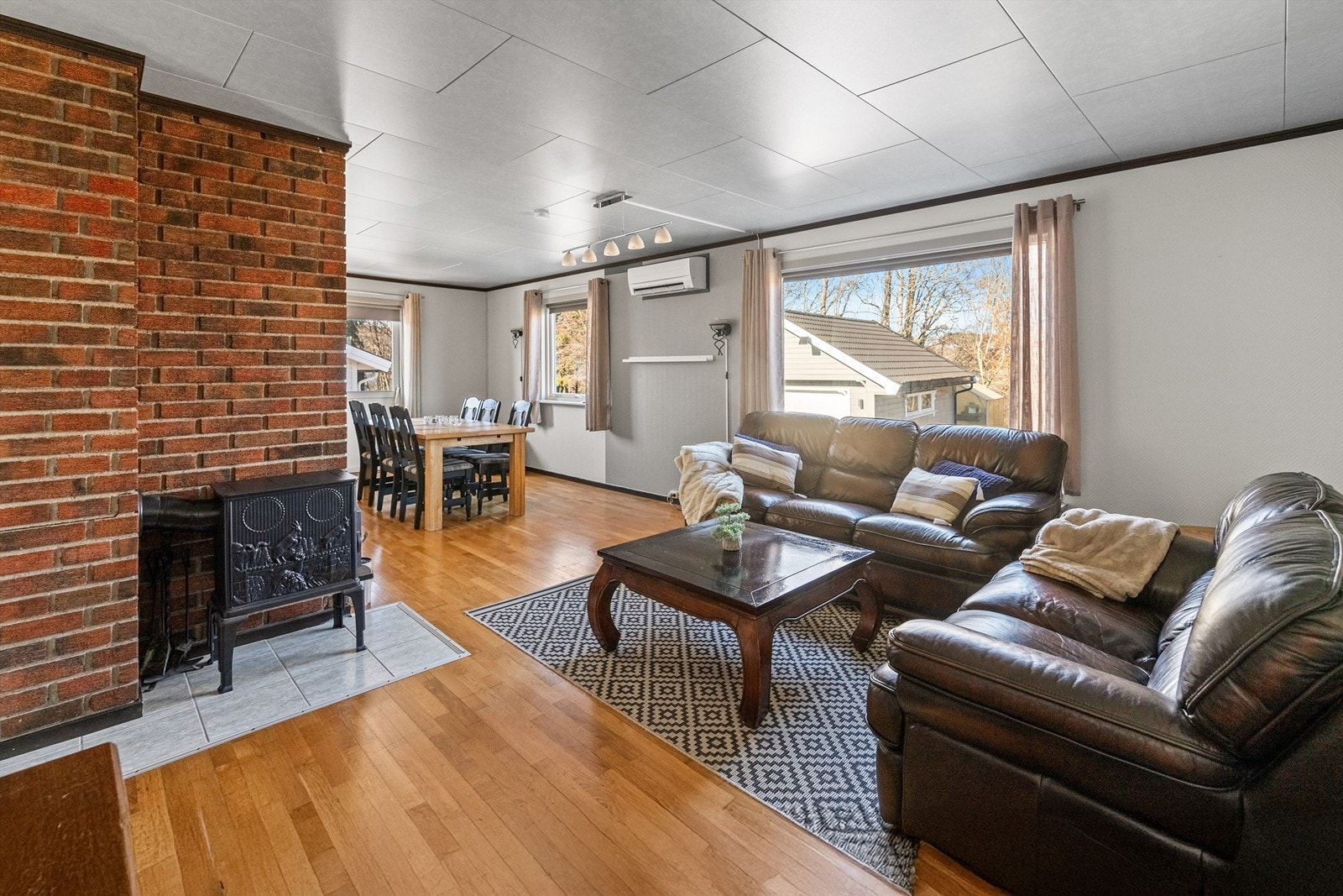 Lys og innbydende stue. Det er montert både varmepumpe og peisovn. Selger opplyser at varmepumpen ble montert for ca. 2-3 år siden. Galleribilde