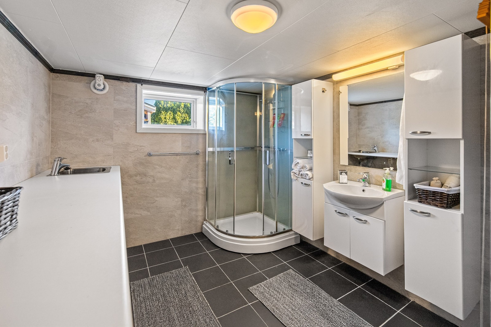 I kjelleren finnes det pent flislagt bad kombinert vaskerom fra ca. 2007. Her er det varme i gulv. Galleribilde