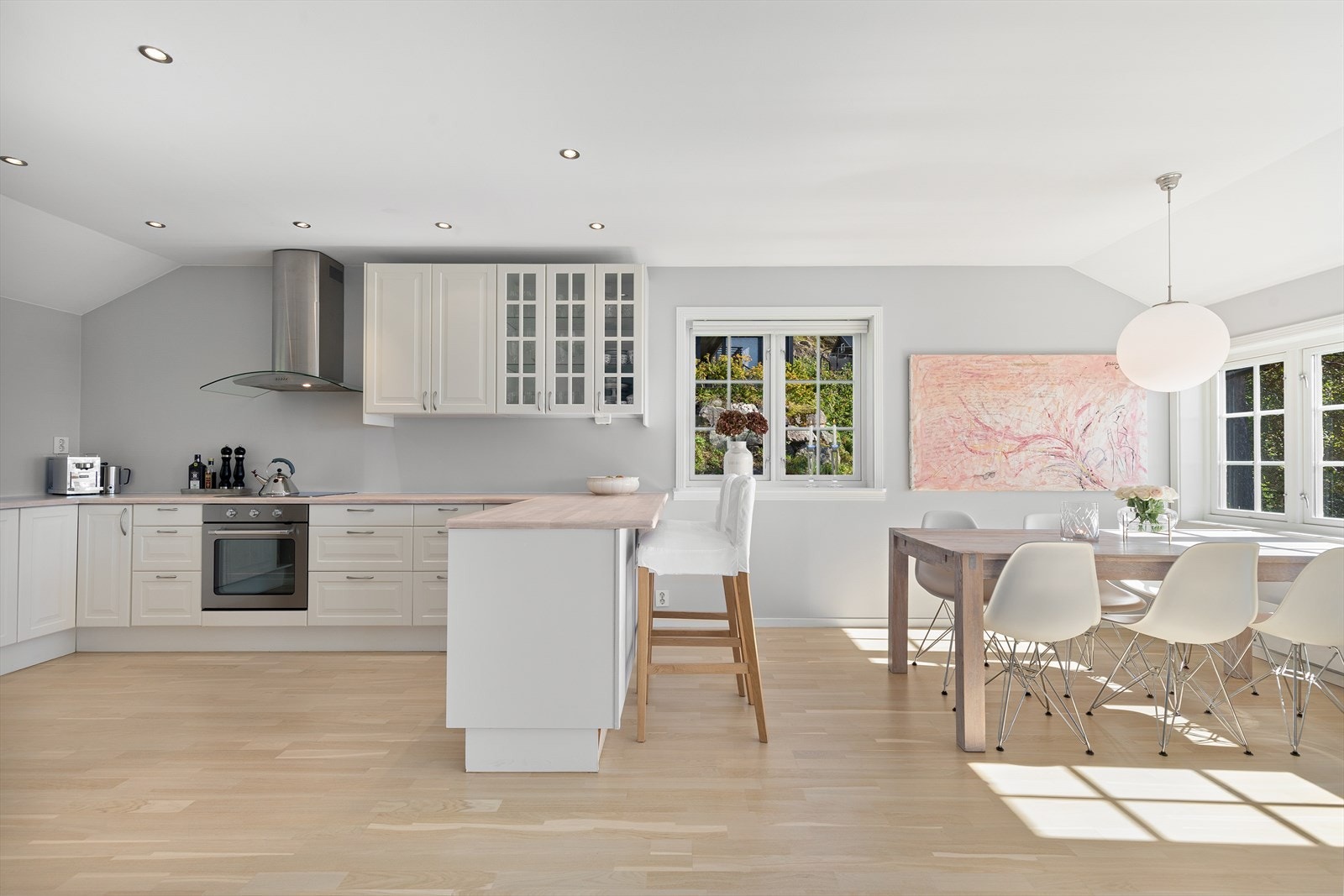 Kjøkkenet har hvite profilerte fronter og integrerte hvitevarer. Galleribilde