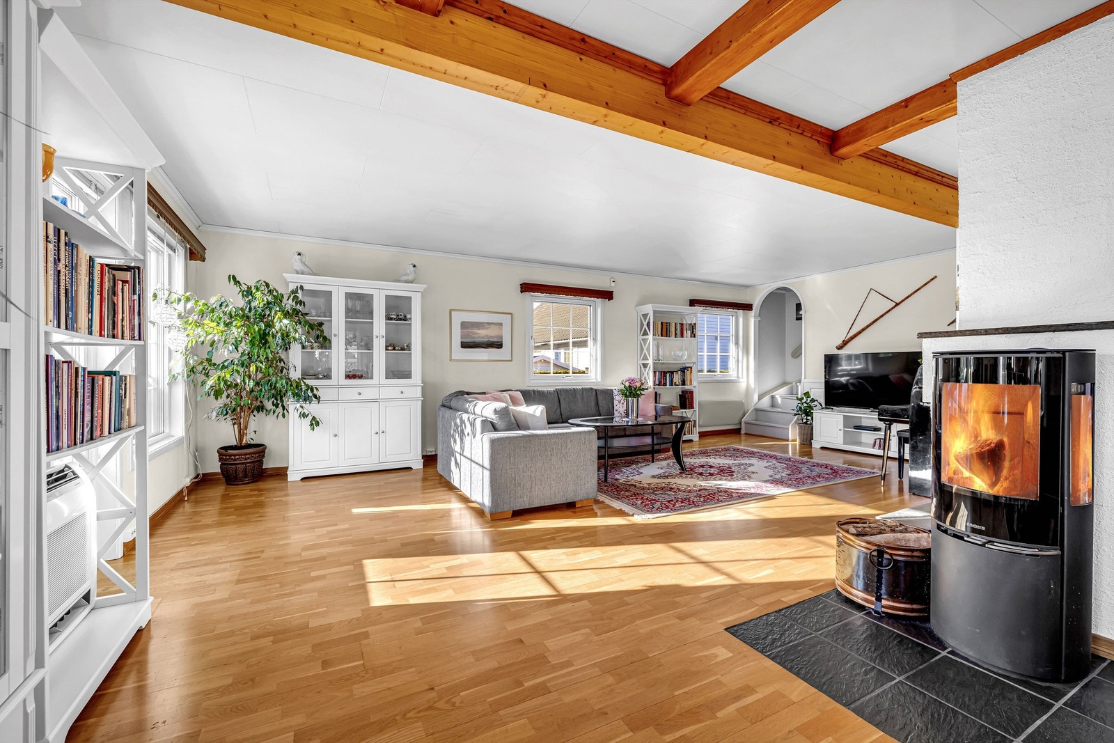 Stuen er innredet med en vedovn som bidrar til ekstra varme og hygge på de litt kjøligere dagene, i tillegg til varmepumpe. Galleribilde