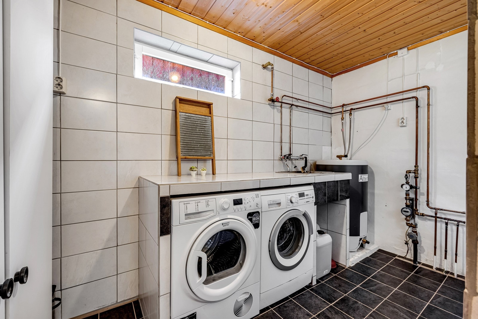 Praktisk vaskerom med plass til oppbevaring, opplegg for vaskemaskin/tørketrommel og utslagsvask. Galleribilde