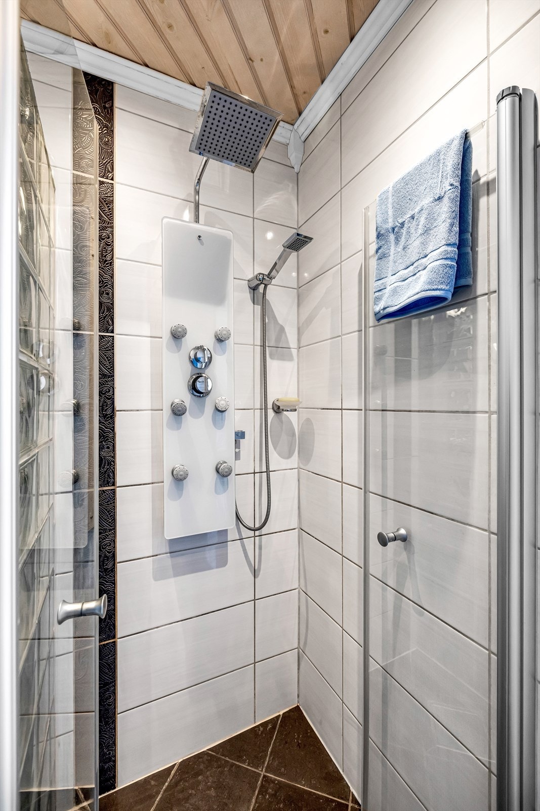 Dusjnisje med vegg av glassbyggerstein, glassdør og armatur. Galleribilde