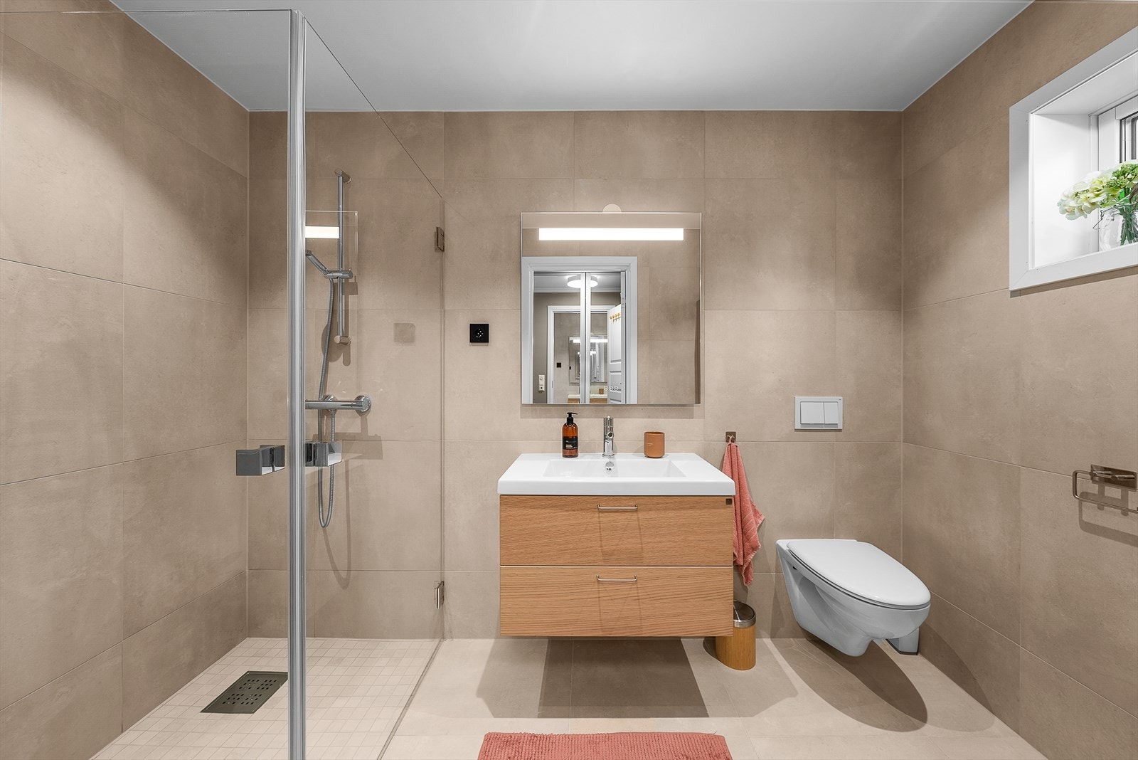 Badet i tilknytning til hovedsoverommet er utført med beige vegg- og gulvfliser, og mosaikkfliser i dusjnisjen. Galleribilde