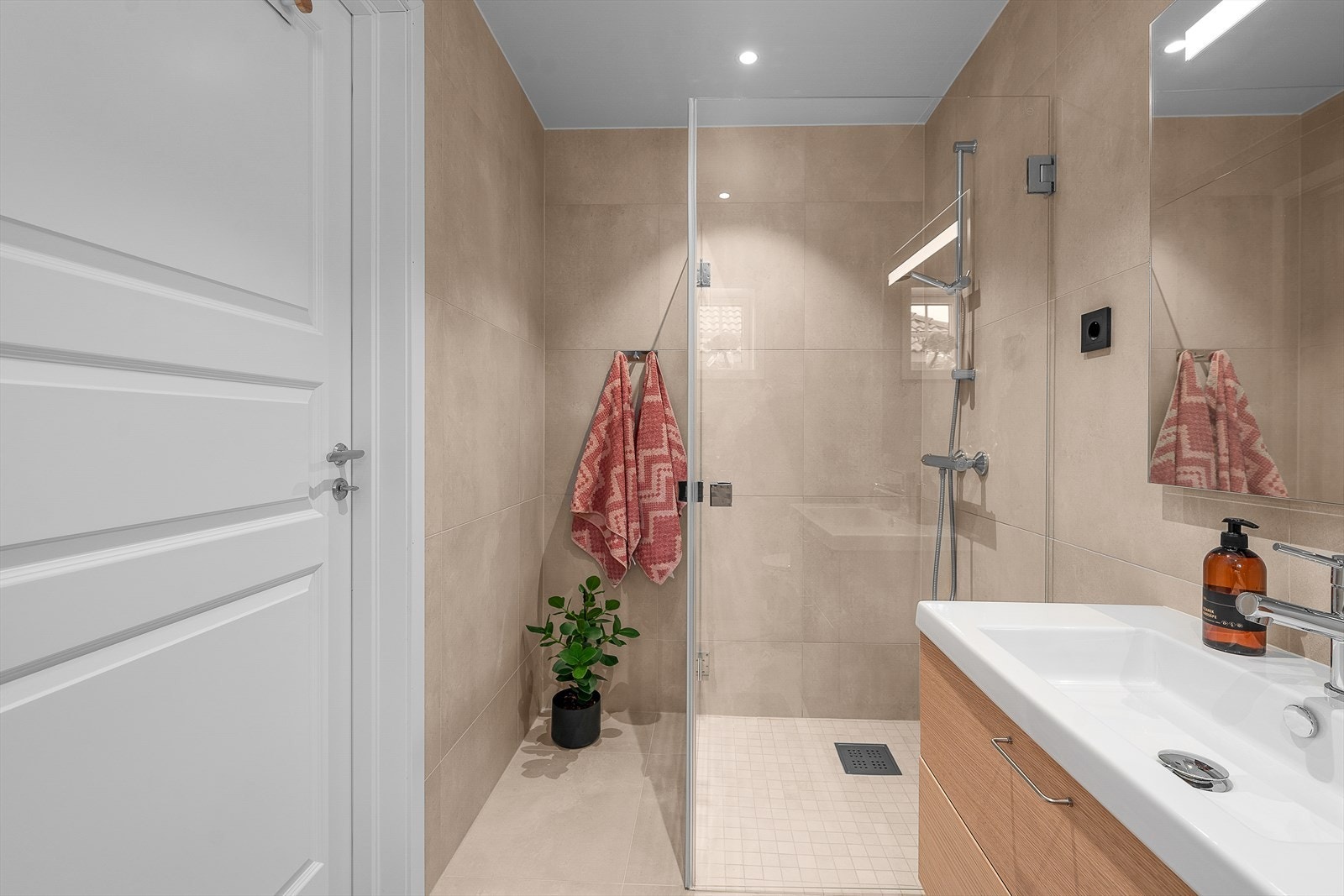 Det er vegghengt toalett, servantskap, lys med speil og dusjhjørne med innfellbare glassvegger. Varmekabler i gulv. Galleribilde