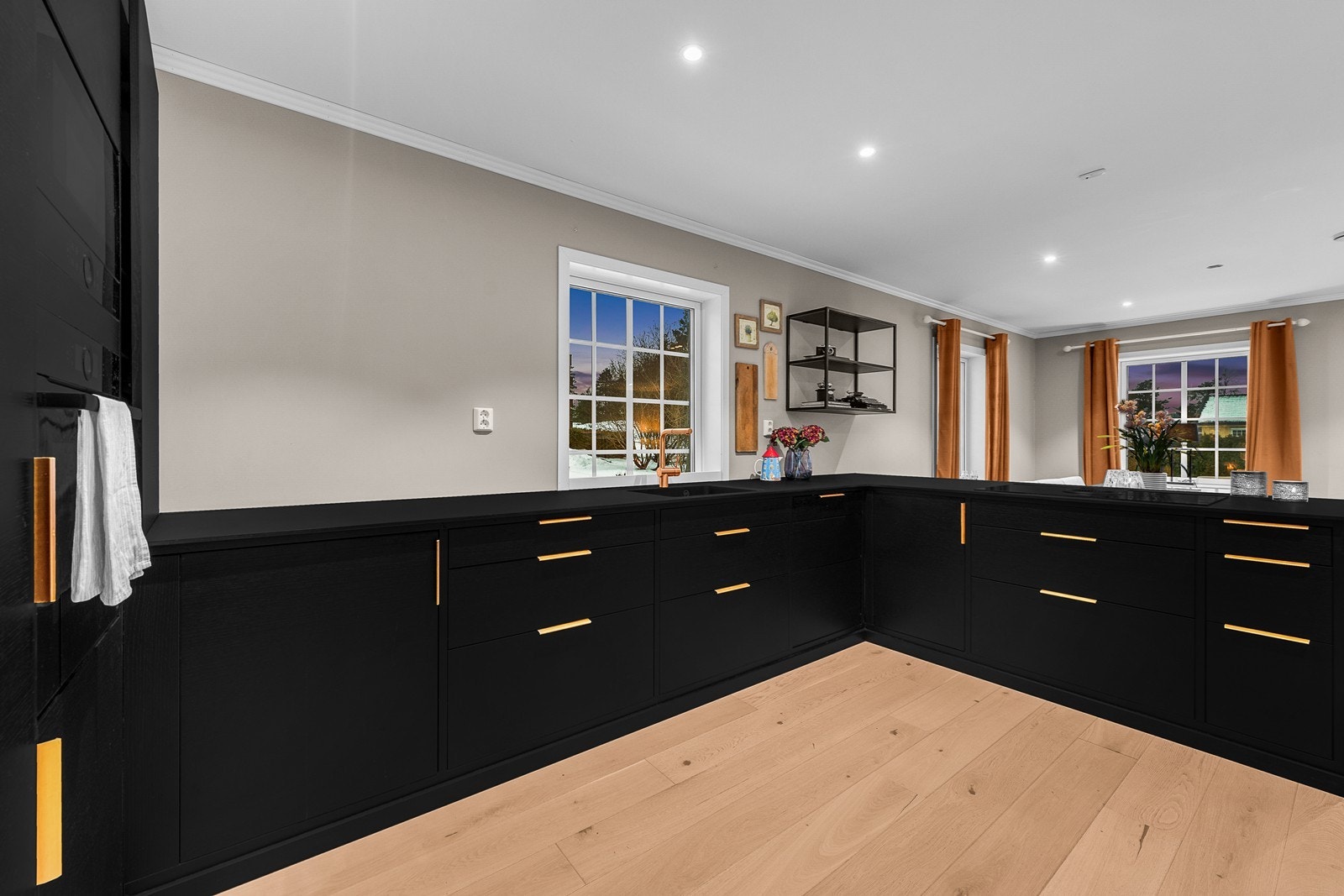 Innredningen er moderne og har glatte fronter i sort, med håndtak i en lekker rust/kobbertone. Benkeplaten er av kompaktlaminat. Galleribilde