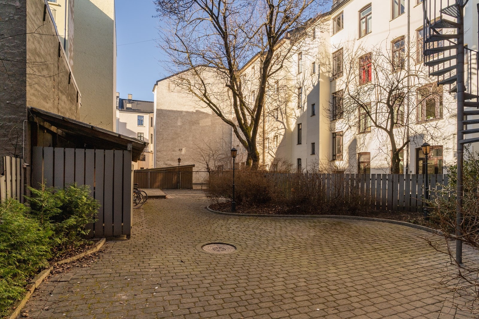 Meget pent opparbeidet gårdsrom. Stensatt og med beplantning, lekeapparat og sittegruppe. Galleribilde