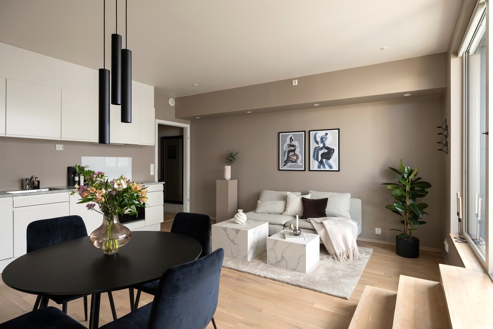 Den åpne løsningen mot kjøkkenet gir en sosial og romslig følelse, med god plass til både sofagruppe og spisebord. Galleribilde