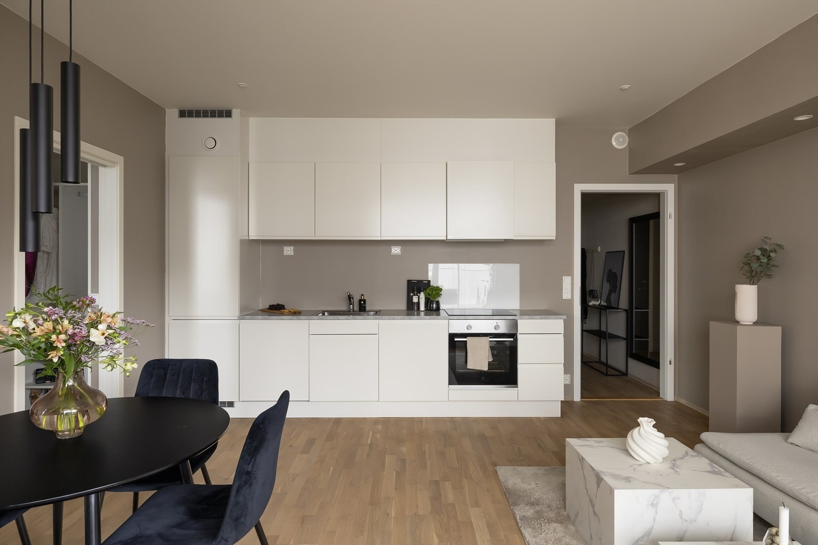 Leiligheten har et stilrent HTH-kjøkken fra byggeår, med hvite, slette fronter og en slitesterk laminat benkeplate med nedfelt benkebeslag. Galleribilde