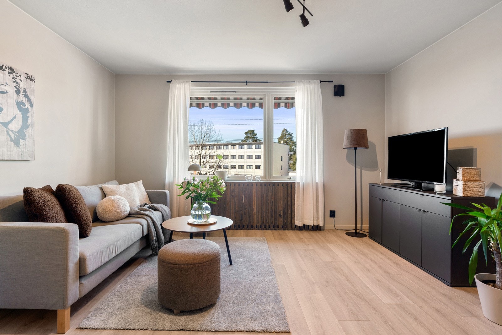 Et romslig oppholdsrom med fleksibel planløsning. Rikelig med sollys fra stort vindu. Galleribilde