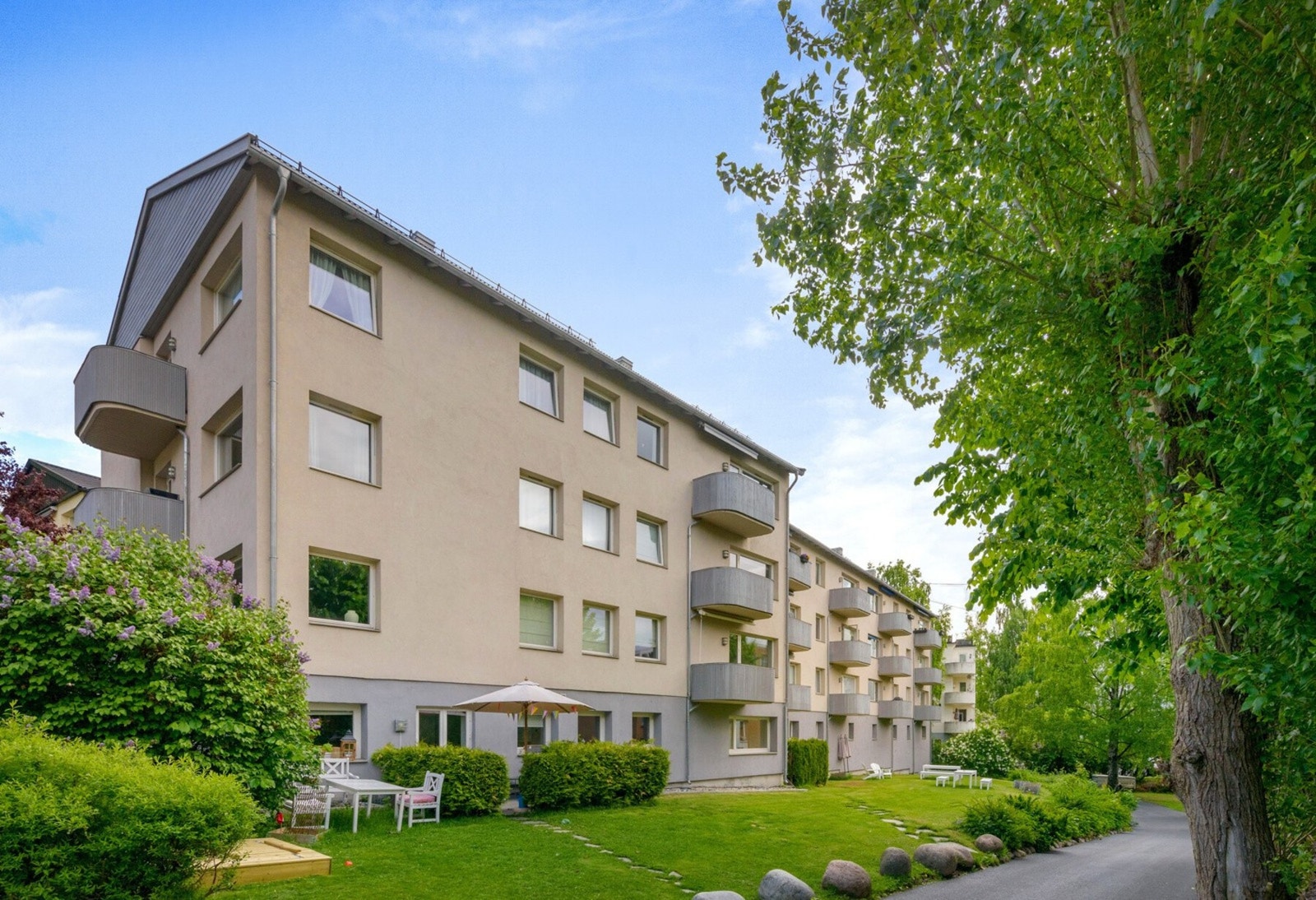 Sommer i Gustav Vigelands vei 3. Blokkene omkranses av store, frodige trær og hyggelige grøntarealer Galleribilde