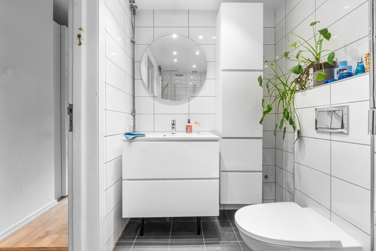 Flislagt bad, pusset opp i regi av sameiet i 2018. Gulvvarme, vegghengt toalett og godt med oppbevaringsplass i skuffer og skap Galleribilde