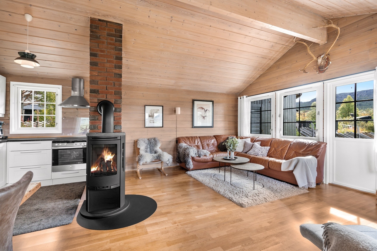 Kjøkken og stueløsning hvor naturen kommer flott inn, og man ivaretar den flotte utsikten. Peisovn. Galleribilde