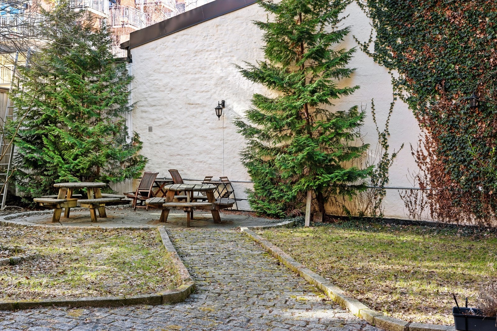 Skjermet bakgård med flere sittegrupper. Galleribilde