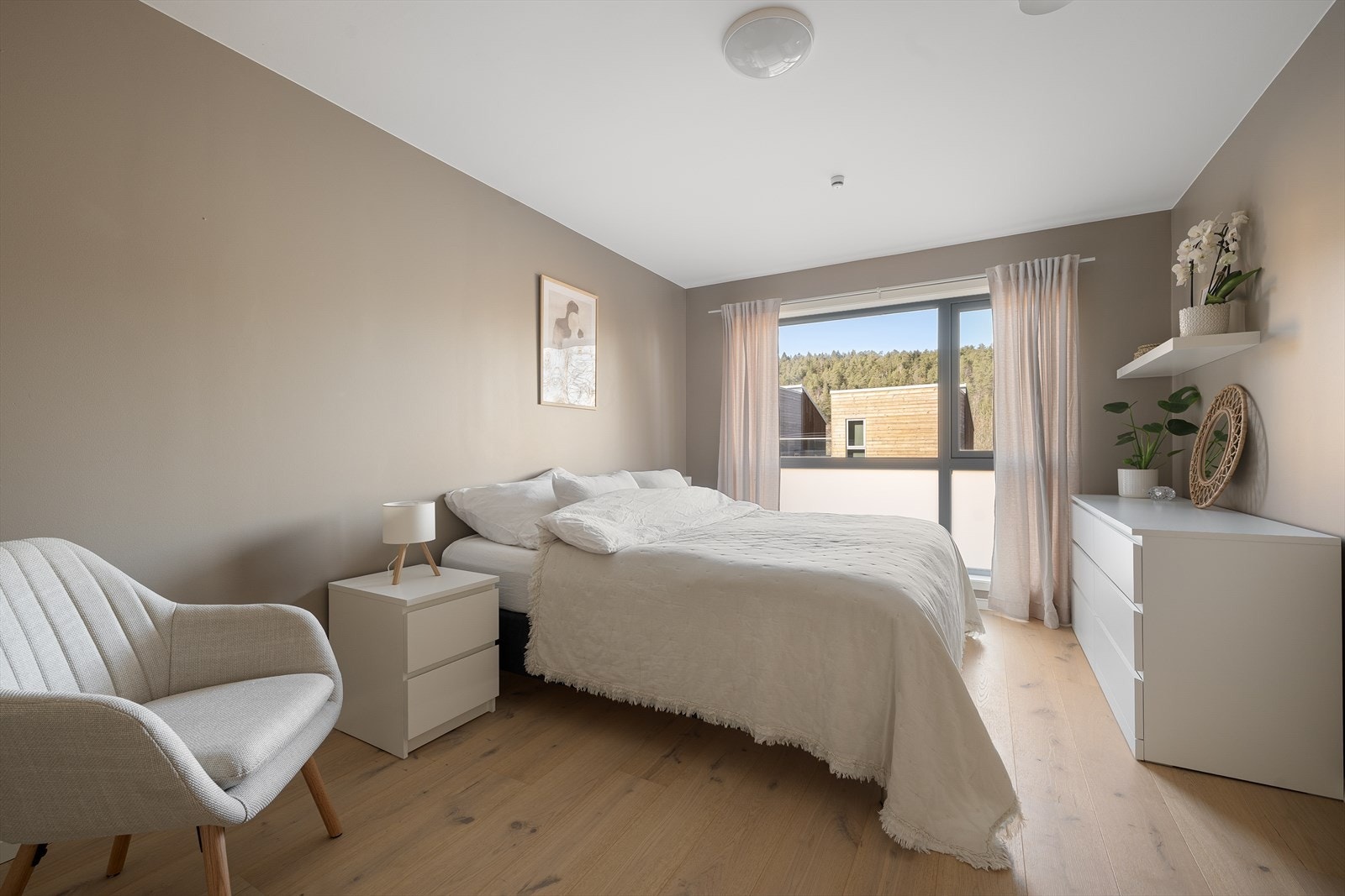 Luftig hovedsoverom med god plass til stor dobbeltseng, nattbord og tilhørende soveromsmøblement Galleribilde