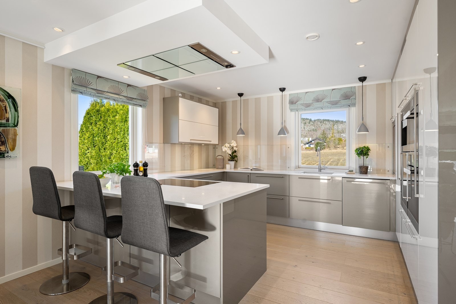 Crown-kjøkkeninnredning fra 2015 med benkeplater av "Minerva (kompositt), slette skapfronter, plateslått
backsplash og ventilator med utkast til friluft. Galleribilde