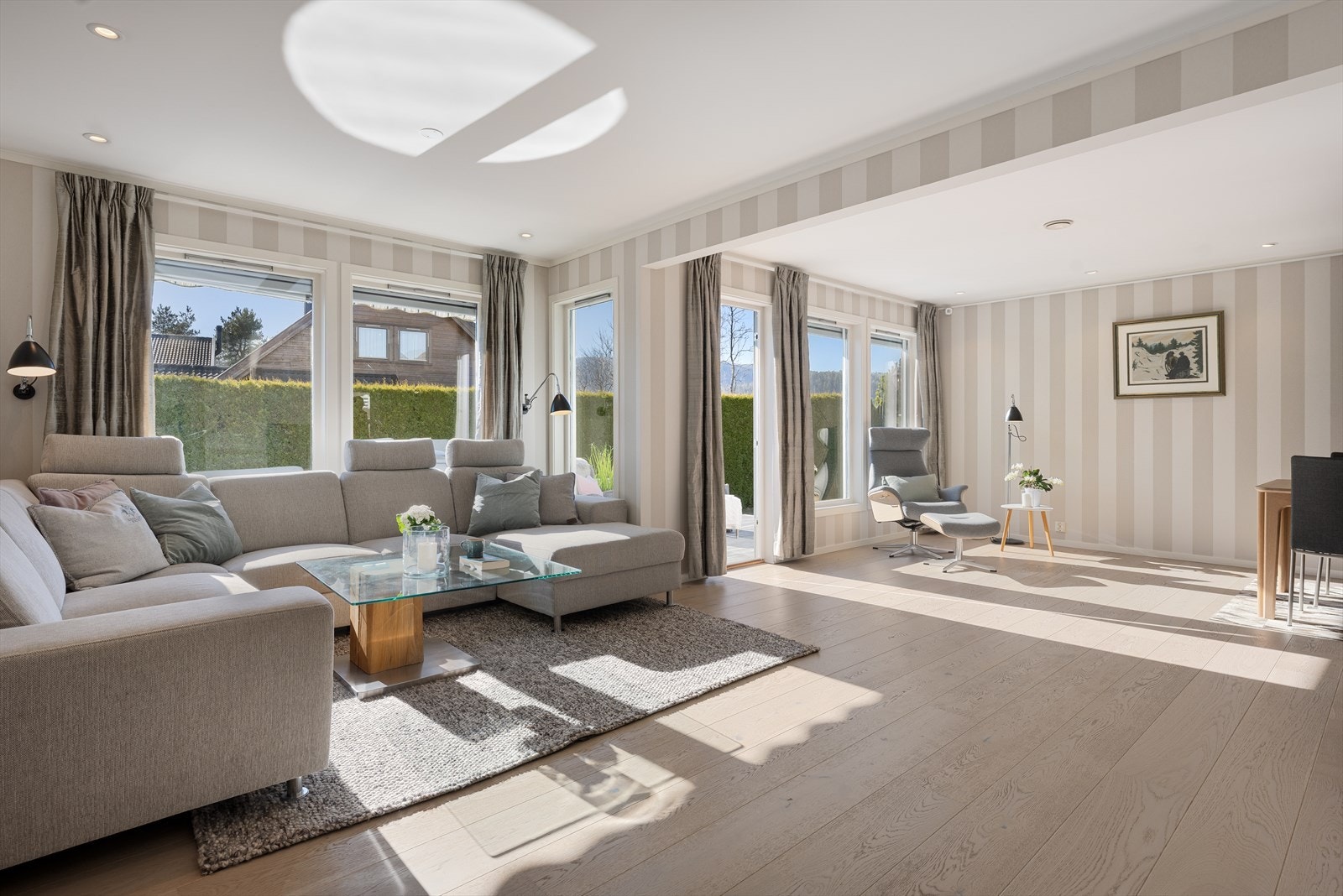 Den delikate stuen, med åpen løsning mot kjøkkenet, har store vindusflater som sørger for rikelig med lysinnslipp fra ulike himmelretninger og skaper en hyggelig atmosfære. Galleribilde