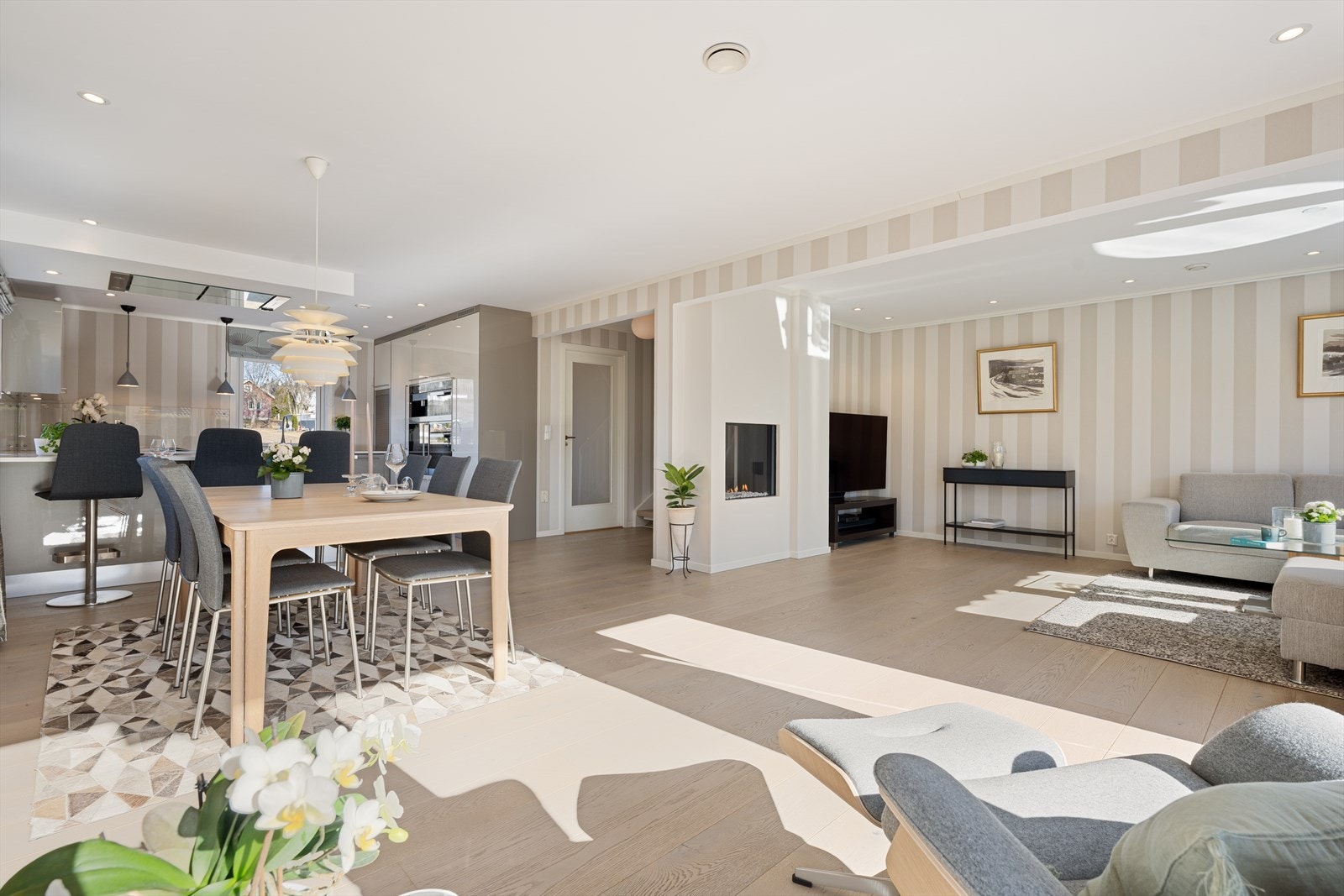 Den åpne løsningen mellom stue og kjøkken skaper en sosial- og luftig atmosfære. Galleribilde