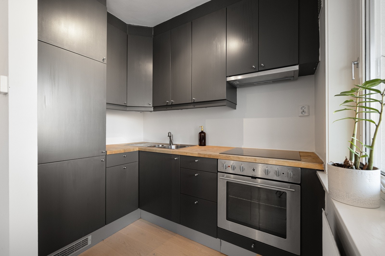 Stilrent kjøkken med glatte fronter og heltre benkeplate. Her er det god plass til å lage mat i godt lag. Galleribilde