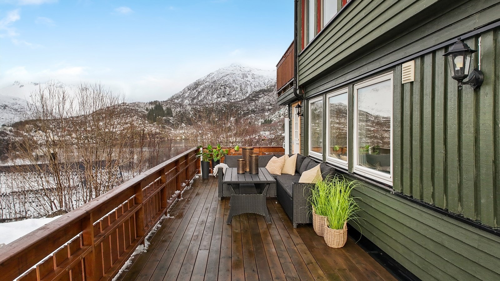 Det er en suveren utsikt mot sjøen og fjellene fra terrassen Galleribilde