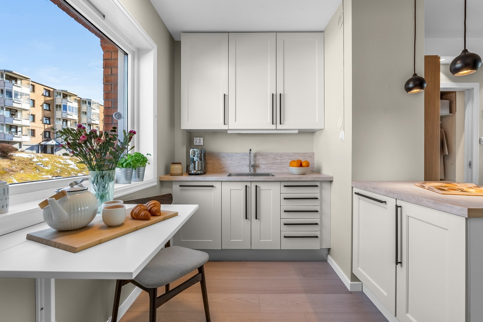 Videre er det nedfelt oppvaskkum i rustfritt stål og benkeplate i laminat som strekker seg oppover vegg i sprutsonen. Galleribilde