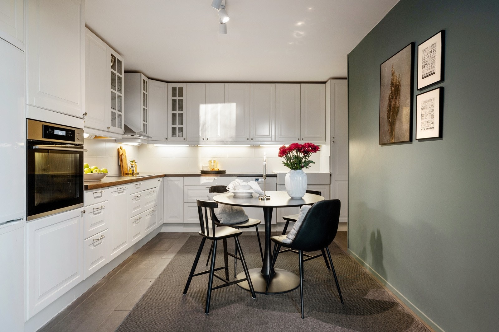 Kjøkkenet har profilerte hvite fronter og benkeplater av laminat Galleribilde