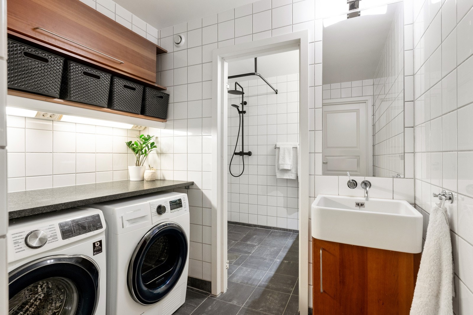 Leiligheten har et stort bad praktisk oppdelt i soner med toalettrom, vaskerom og bad Galleribilde