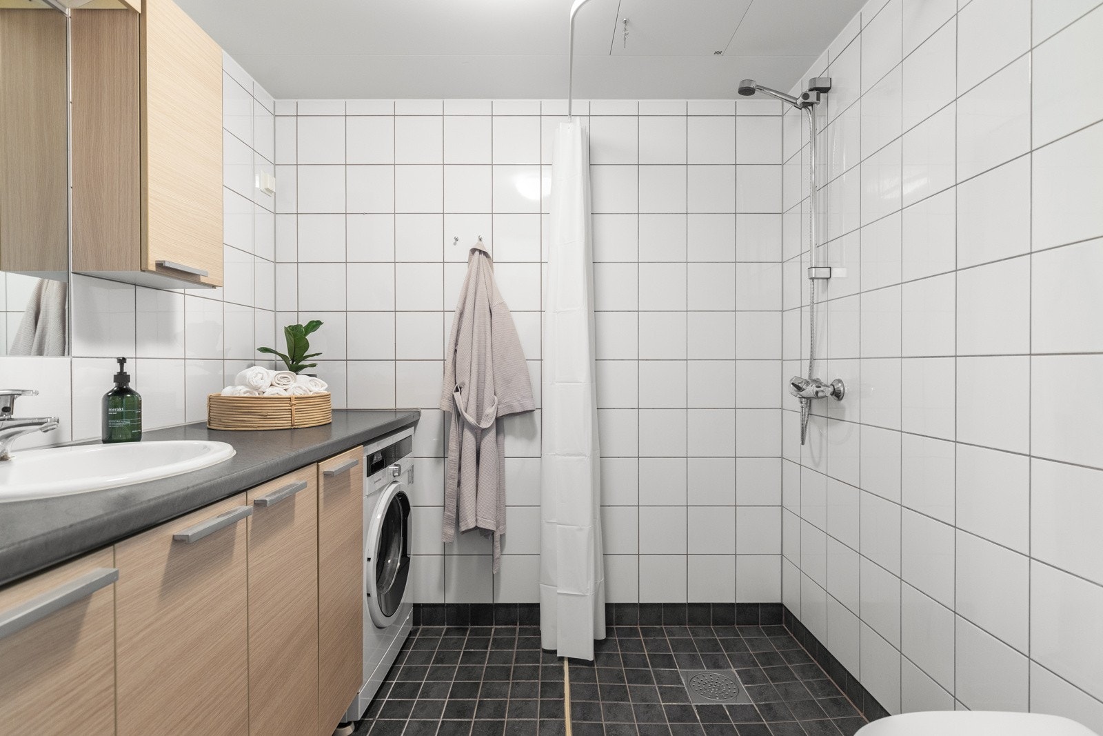 Flislagt bad med gulvvarme og opplegg for vaskemaskin. Galleribilde