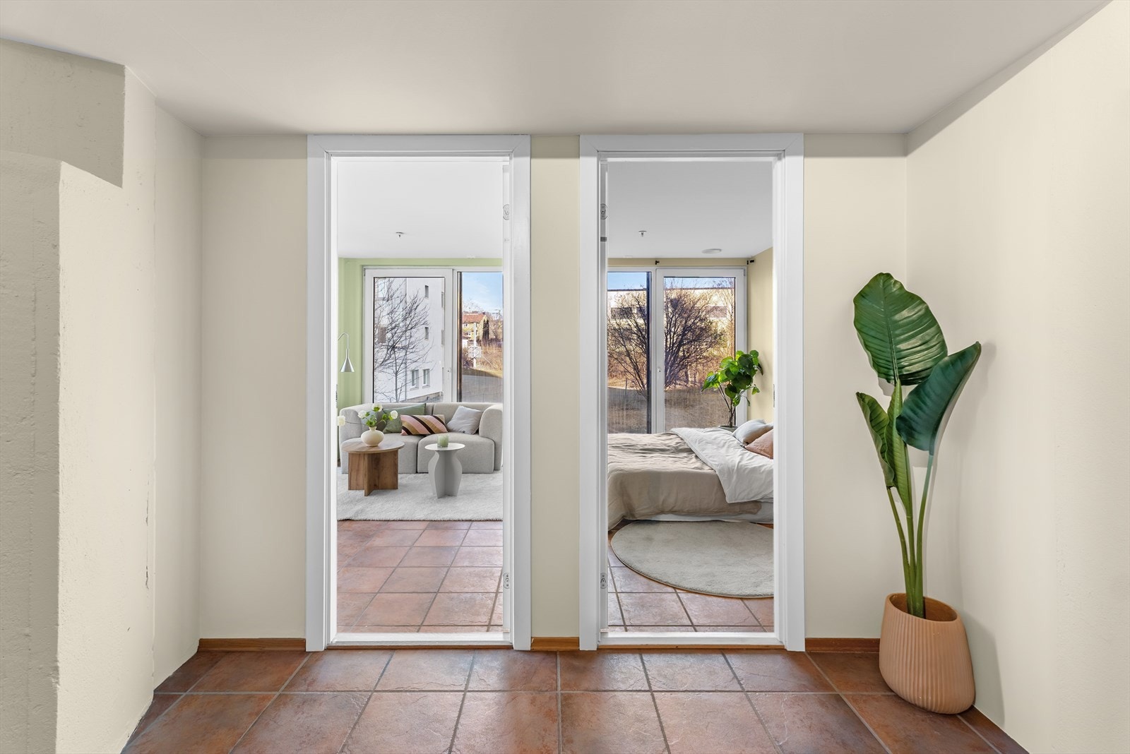 Stuen og soverommet ligger innenfor kjøkkenet, med samme type fliser på gulvet. Galleribilde