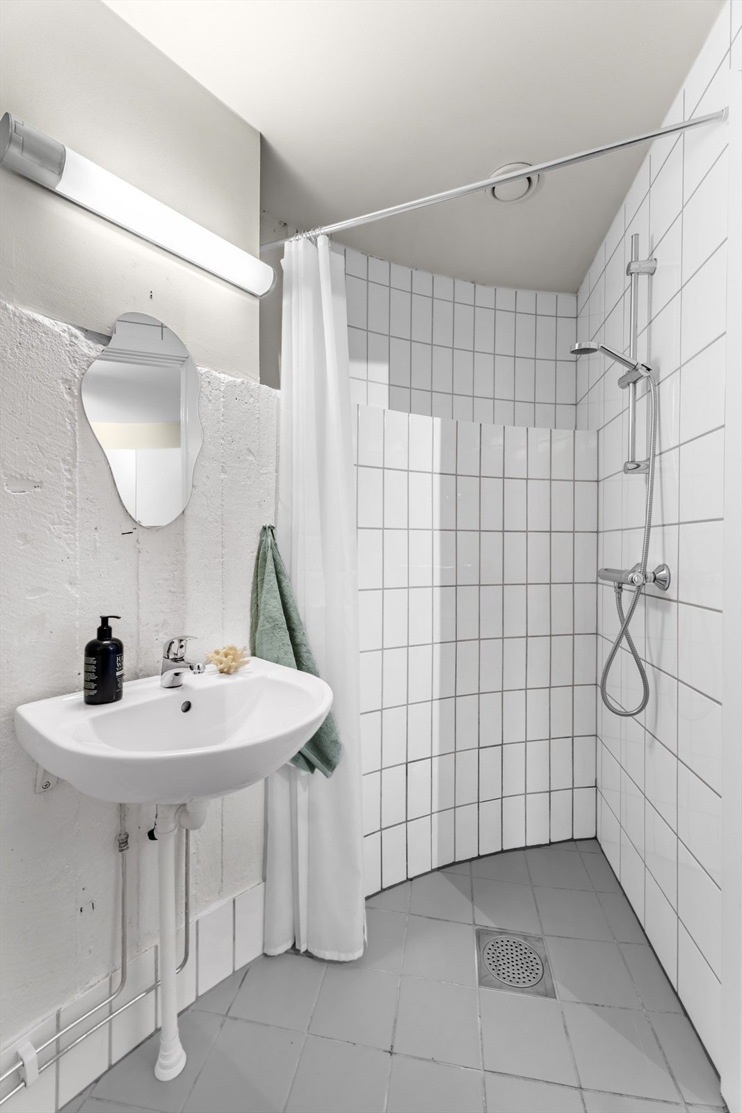 På badet er det toalett, servant og et åpent dusjhjørne. Galleribilde