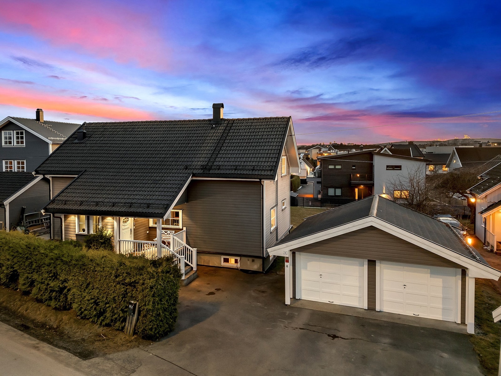 Dobbelgarasje med 2 leddporter. Ladepunkt for El-bil er montert på vegg. Galleribilde