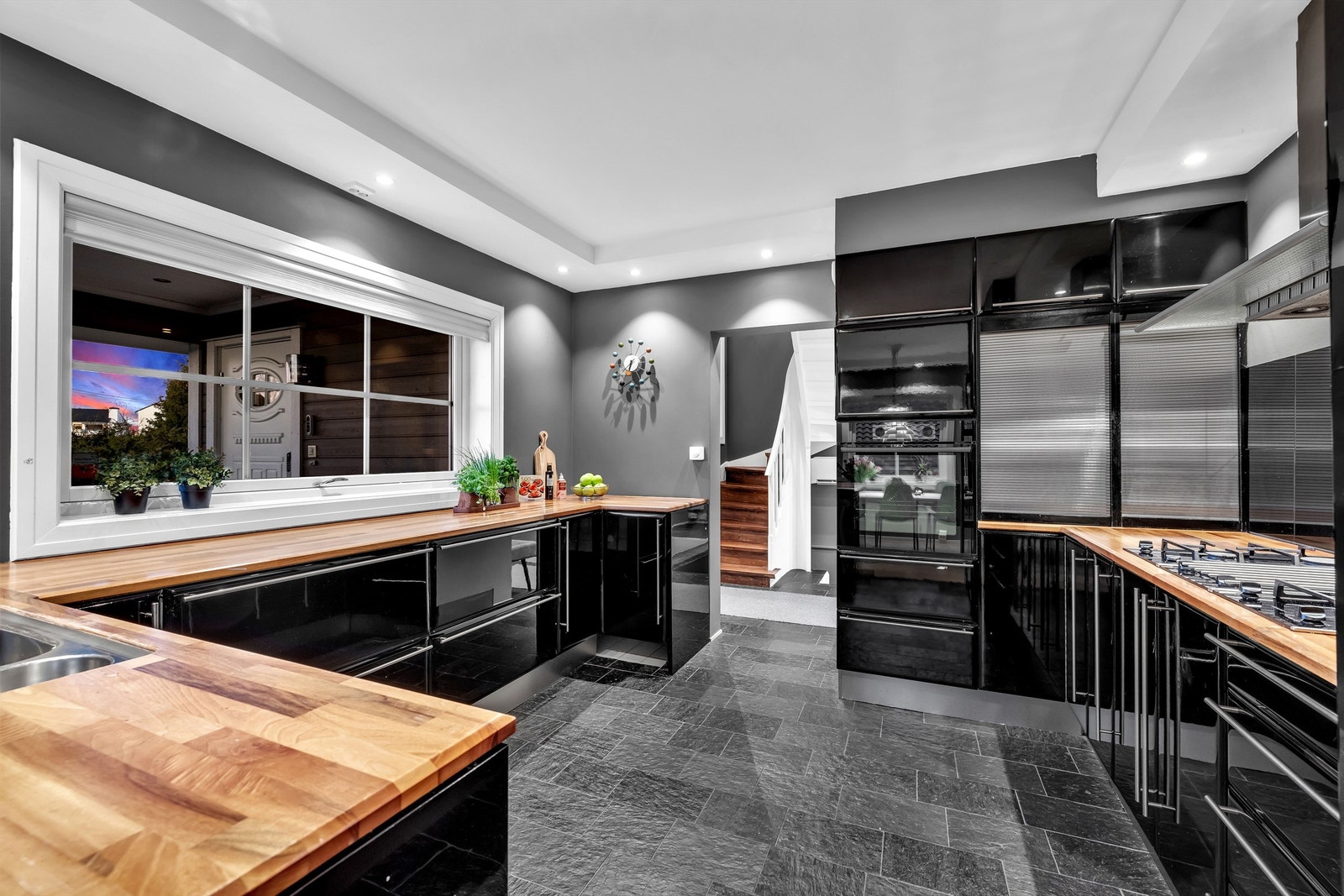 Lekkert kjøkken med høyglans fronter og delvis integrerte hvitevarer Galleribilde