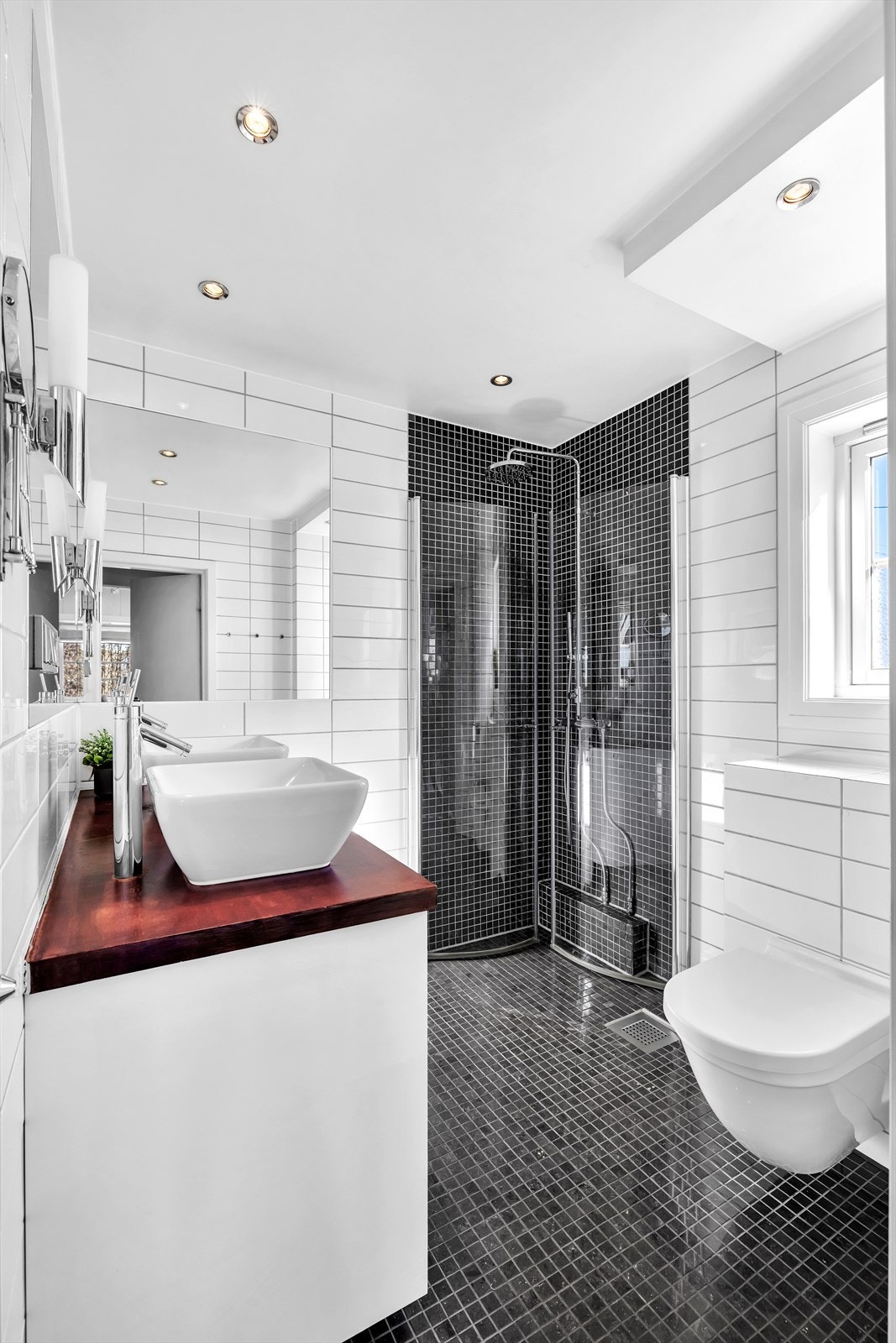 Innbydende bad med innfliset speil, downlights, samt dusjhjørne med hånddusj og deilig regnfallsdusj Galleribilde