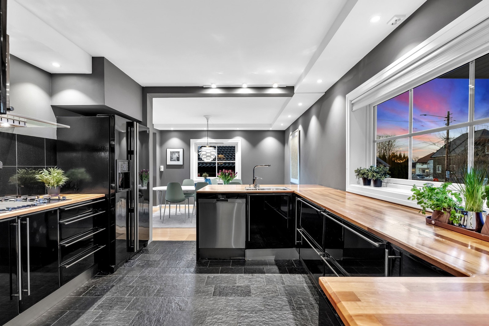 Det flislagte gulvet harmonerer fint med den mørke kjøkkeninnredningen og skaper et eksklusivt uttrykk Galleribilde