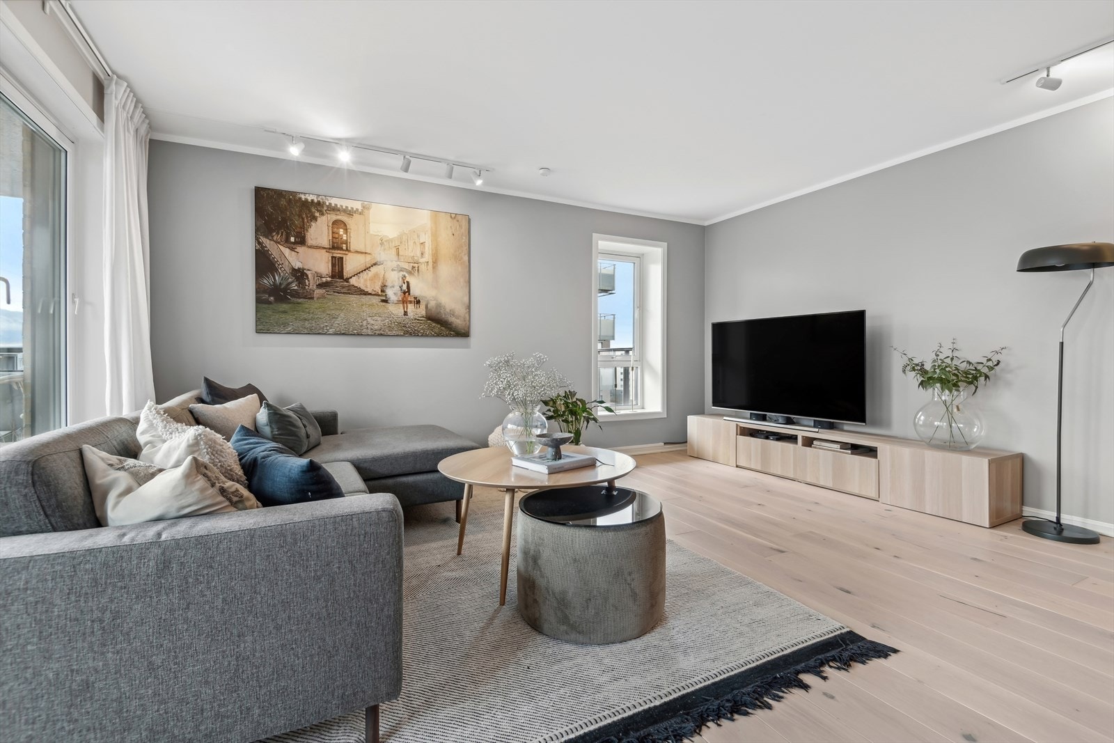 Stue med lys innredning og plass til underholdning. Galleribilde