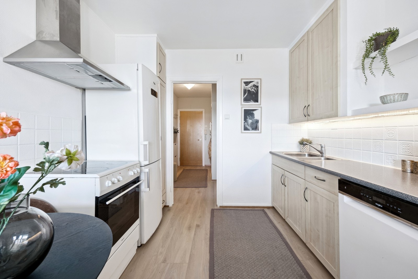 Lys kjøkkeninnredning med originale, plassbygde skrog. Profilerte og folierte fronter Galleribilde