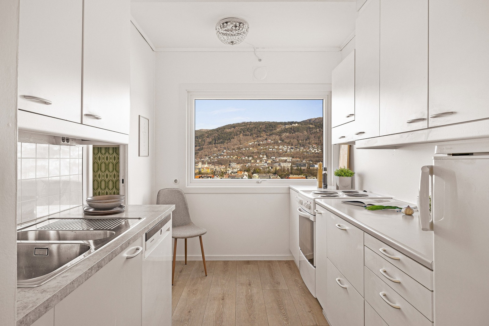 Her er det innredet med hvite, glatte fronter og benkeplate i laminat Galleribilde