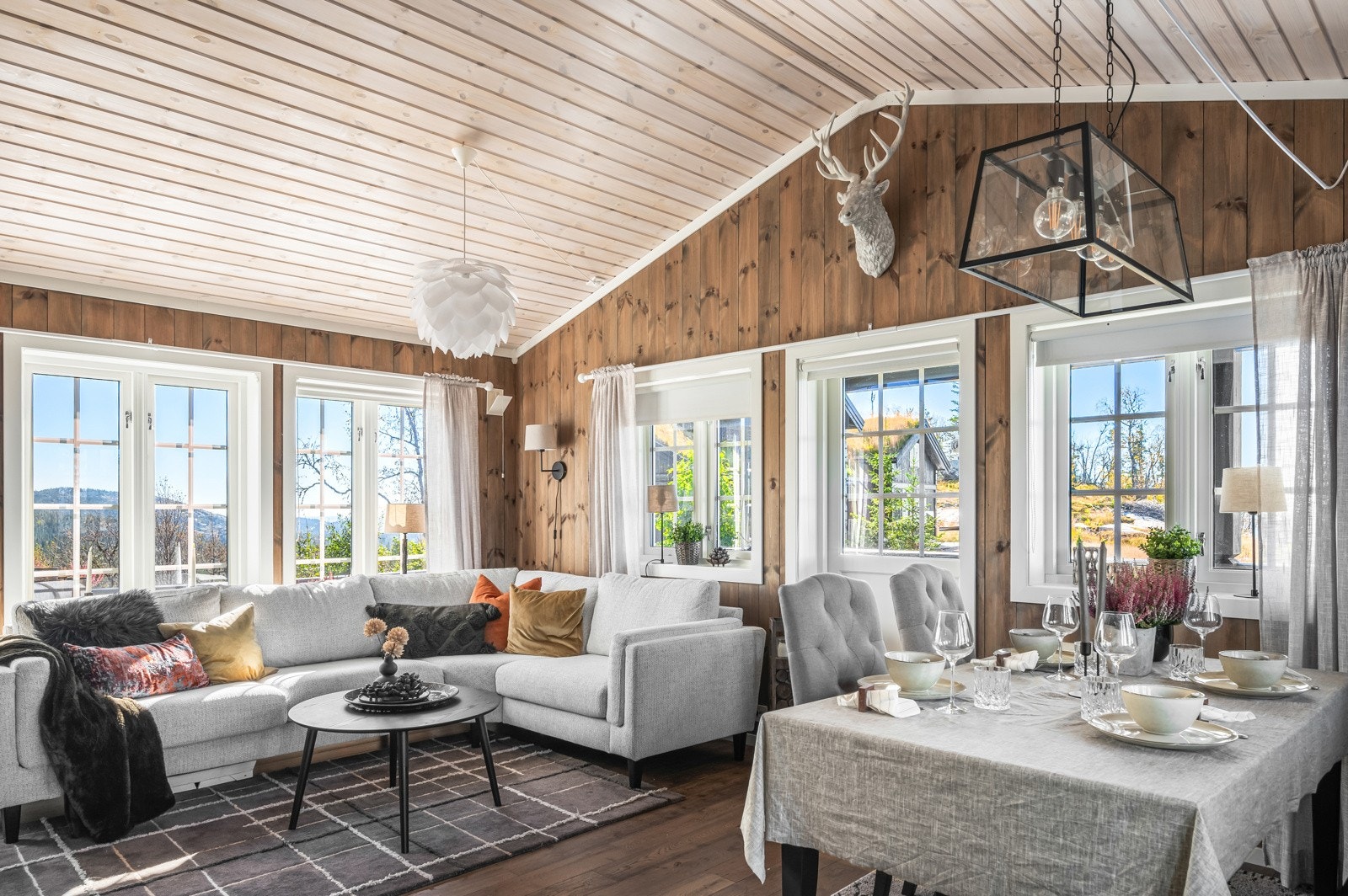 Stuen har mange og store vinduersom slipper lys og natur inn i hytta Galleribilde