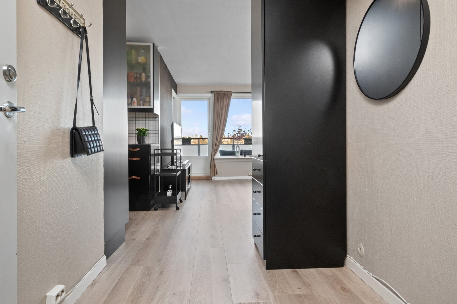 Entreen gir et godt førsteinntrykk - i direkte tilknytning til stuen, og det er montert et sort høyskap. Galleribilde