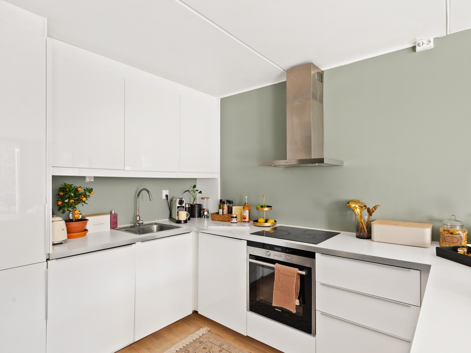 Kjøkkeninnredning fra IKEA med glatte fronter og laminat benkeplate, integrerte hvitevarer som kjøl/fryseskap, oppvaskmaskin, platetopp og stekeovn. Galleribilde