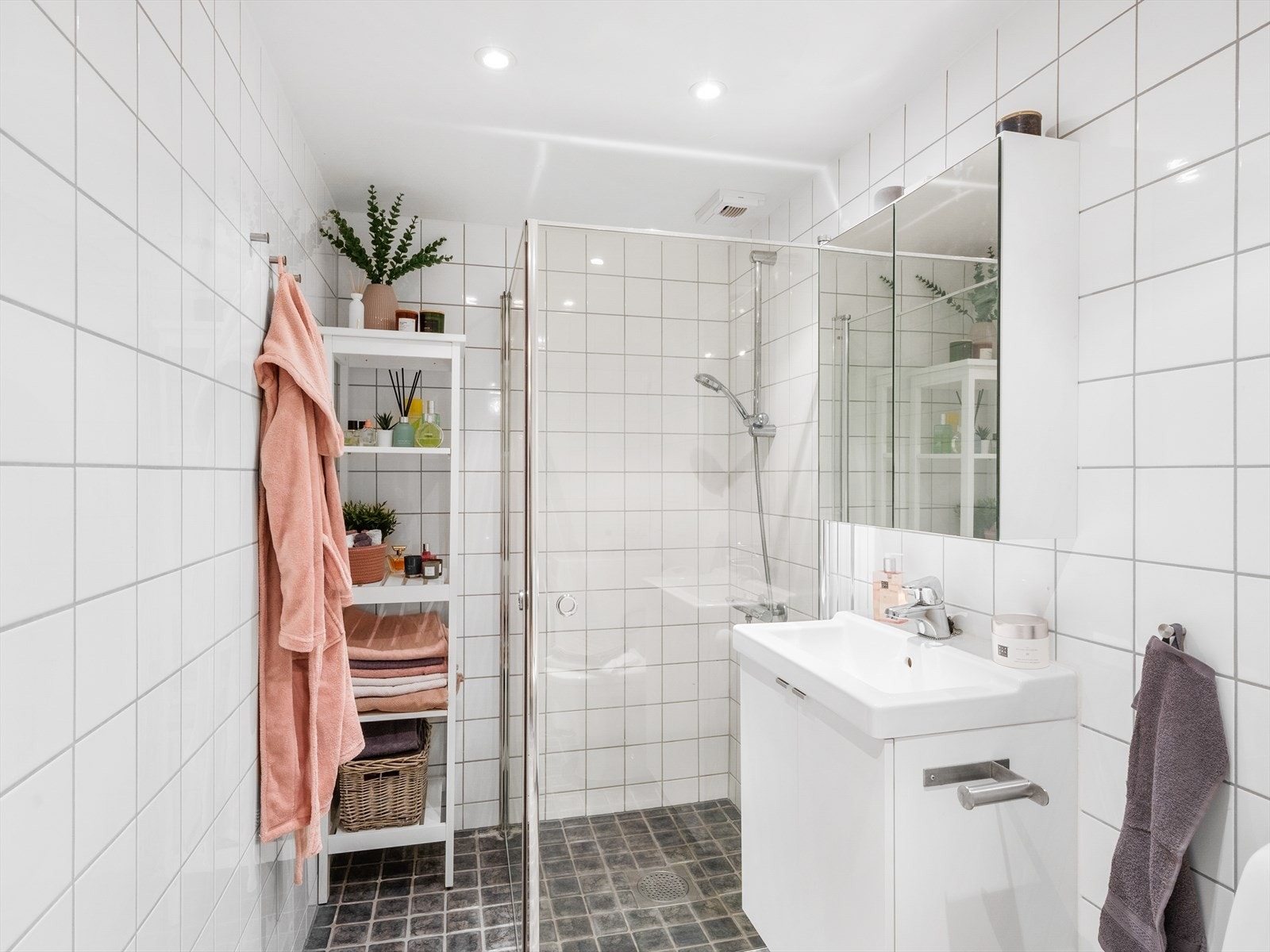 Rommet har overflater av flis på gulv med elektriske varmekabel, flis på vegg og malte plater i tak/himling. Badet har forskriftsmessig fall til sluk. Galleribilde