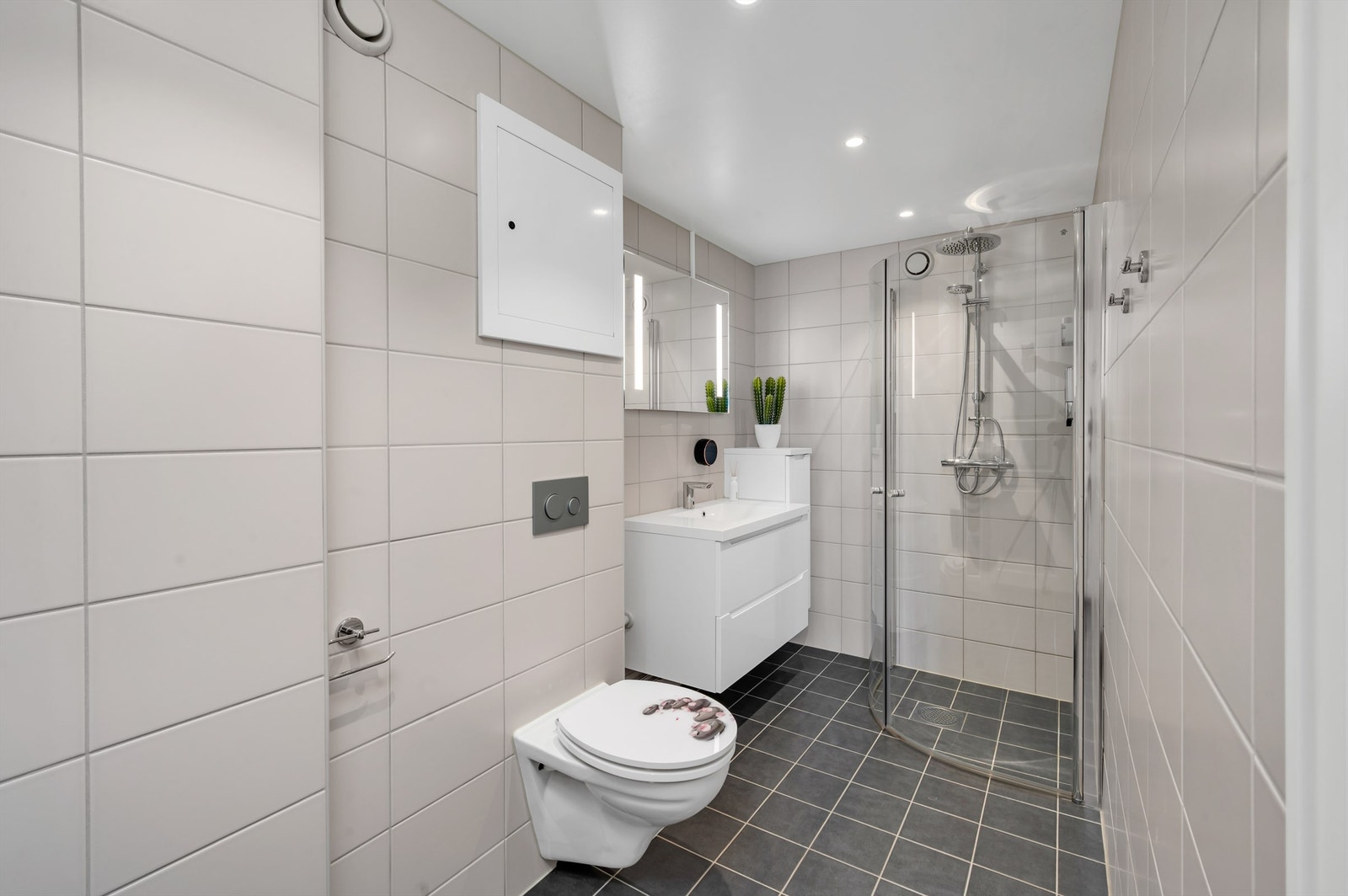 Lekkert bad fra 2018 med fliser på gulv og vegger, og varme i gulvet. Innredningen består av vegghengt servantinnredning med servant. Galleribilde