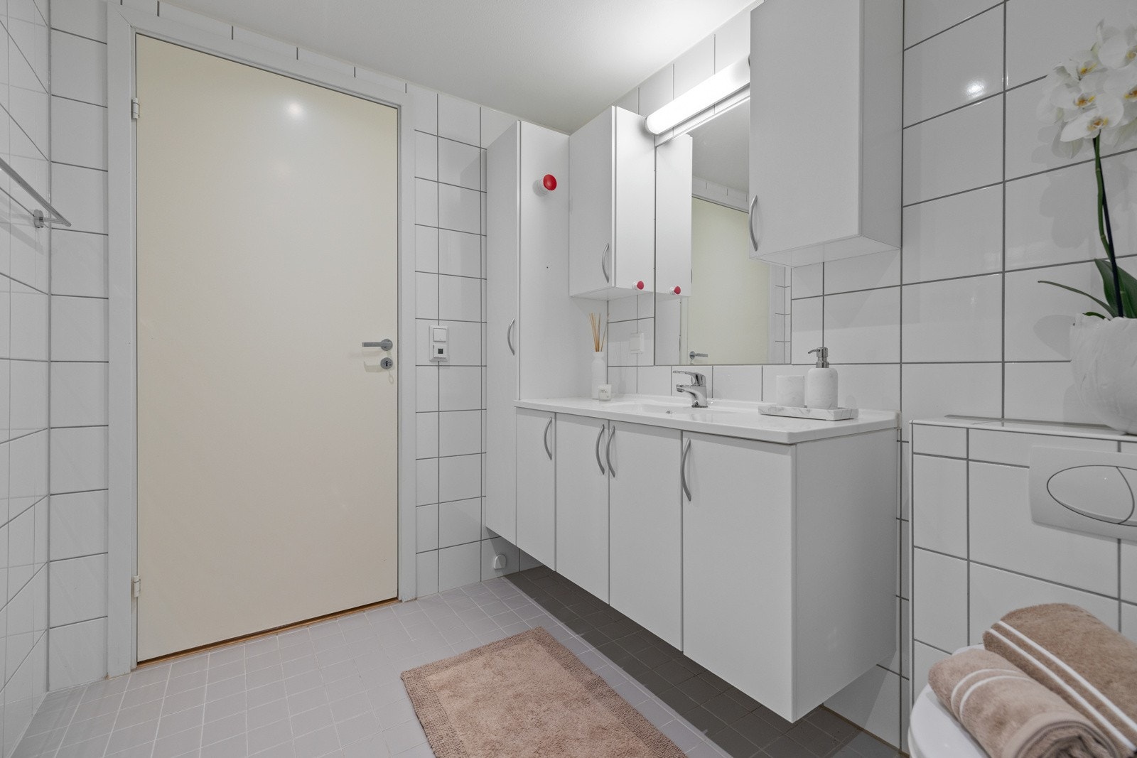 Det flislagte badet er lyst og pent med downlights i himling og elektrisk varme i gulvet Galleribilde