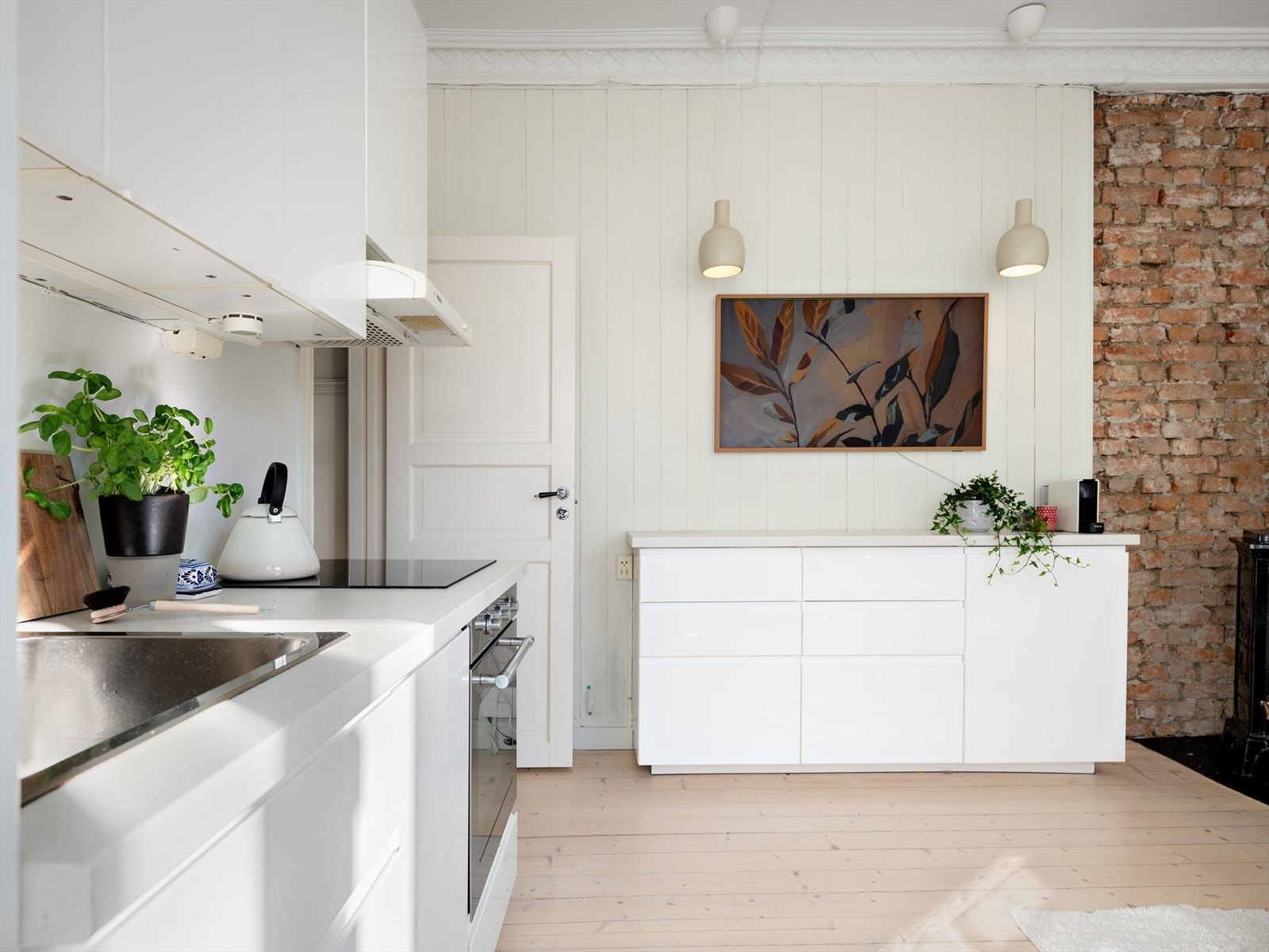 Integrerte hvitevarer fra Ikea/Whirlpool som oppvaskmaskin (smal), kjøl/frys, stekeovn og induksjonsplatetopp. Ekstra arbeids- og oppbevaringsplass på benk i samme utførelse som kjøkkeninnredningen. Galleribilde