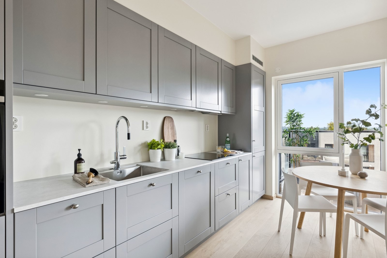 Videre er det slimline kjøkkenhette med forkant i stål, levert av Røroshetta, over koketoppen. Galleribilde