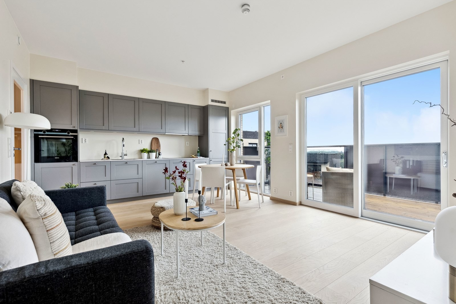 Leiligheten har en åpen stue/kjøkkenløsning som gjør rommet til et hyggelig og sosialt oppholdsrom. Galleribilde