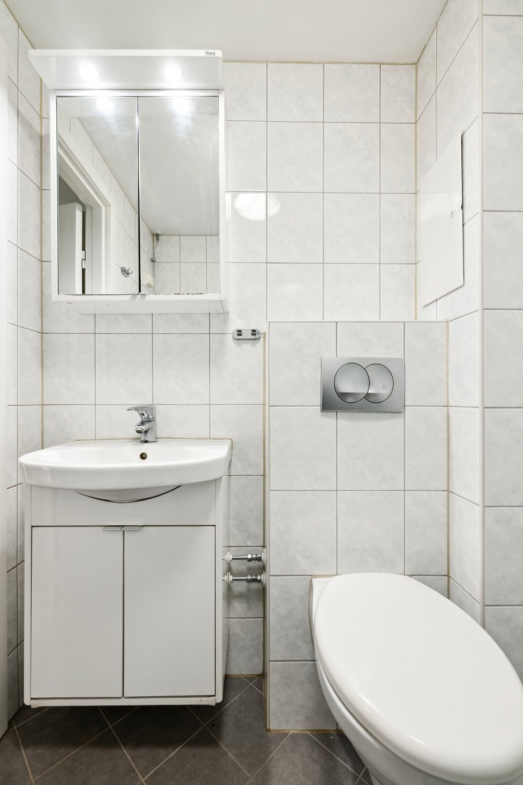 Badet er flislagt med varmekabler i gulv og montert lampe i tak. Galleribilde