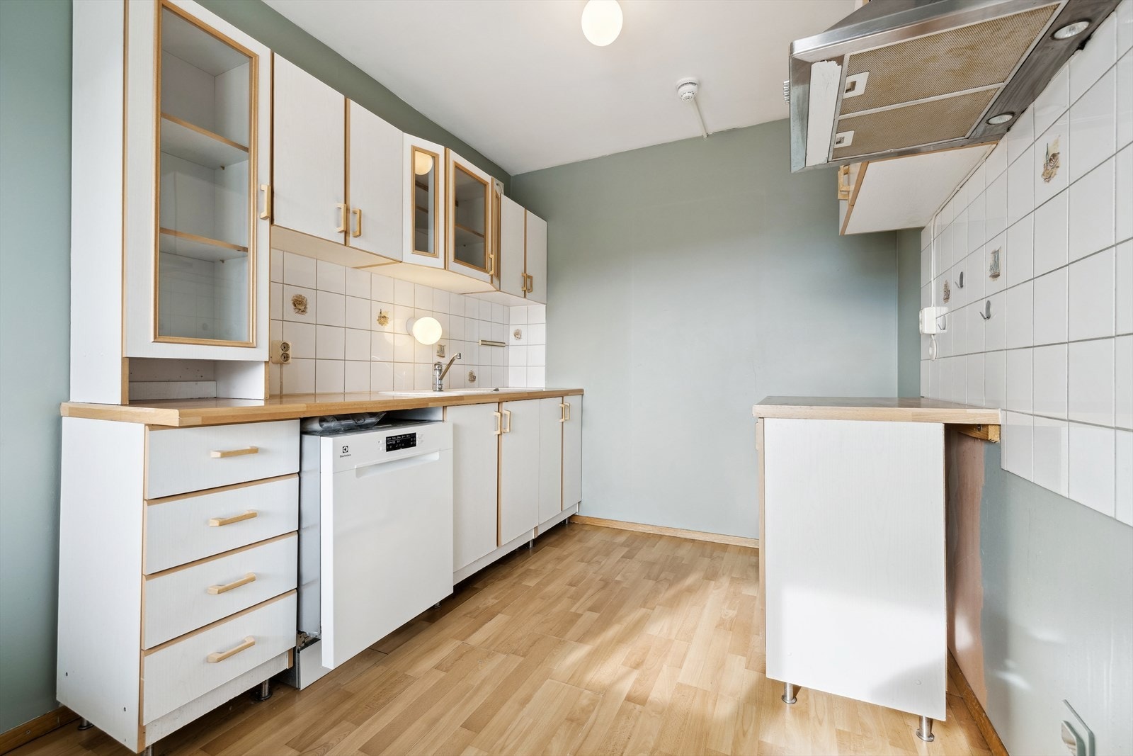 Det romslige kjøkkenet er av god størrelse med slette fronter og laminat benkeplate - det er lagt fliser over benkeplaten. Galleribilde