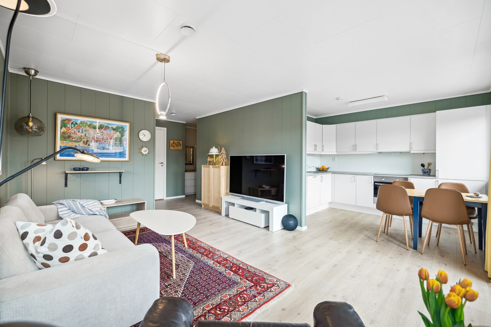 Kjøkkenet har moderne, hvite fronter og laminert benkeplate Galleribilde